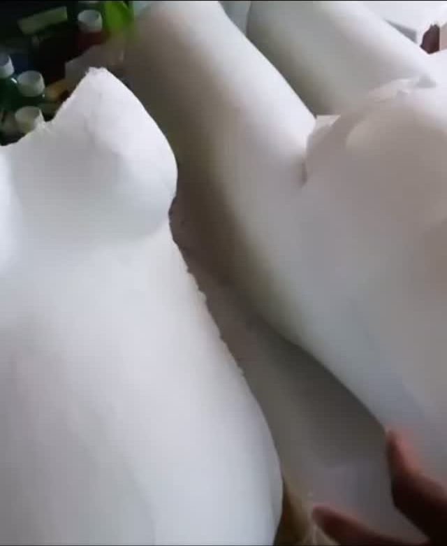 Moulages en plâtre de bustes de femmes enceintes, entourés de pots de peinture
